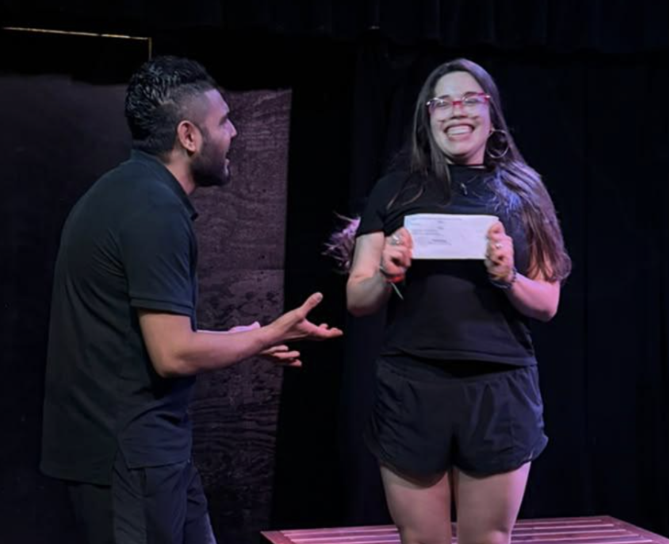 Two actors laughing together over a note