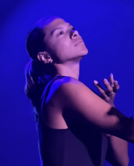 Actor in a dramatic dance pose under blue light