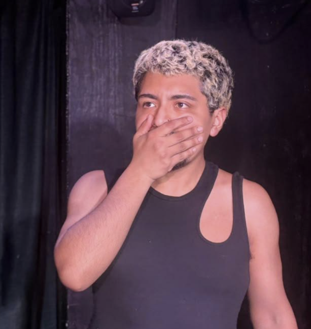 Actor reacting in a scene, hand over mouth