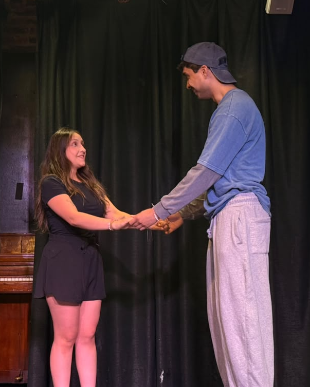 Two actors holding hands in a tender scene