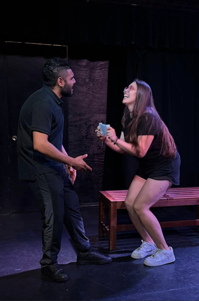 Two actors laughing together in a scene