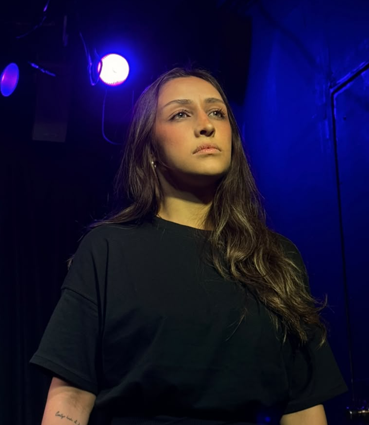 Actress under a blue spotlight on stage