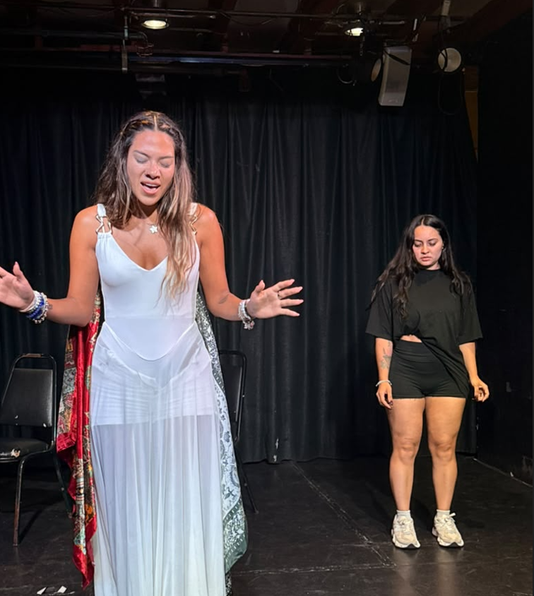 Actress in a white dress singing on stage